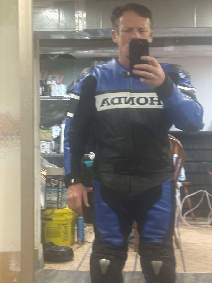 Person wearing a blue and black Honda motorcycle jacket taking a mirror selfie.
