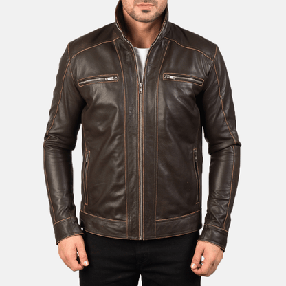 A man wearing a brown leather motorcycle jacket with embroidered leather applique graphics, a zipper front, and pockets at the elbows and shoulders.